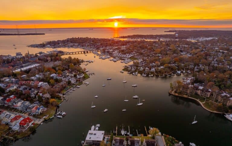 Welcome 10 Experience the best things to do in Rock Hall MD in the fall like this aerial shot of a harbor and Chesapeake Bay at sunset, showing fall leaves, boats, and water.