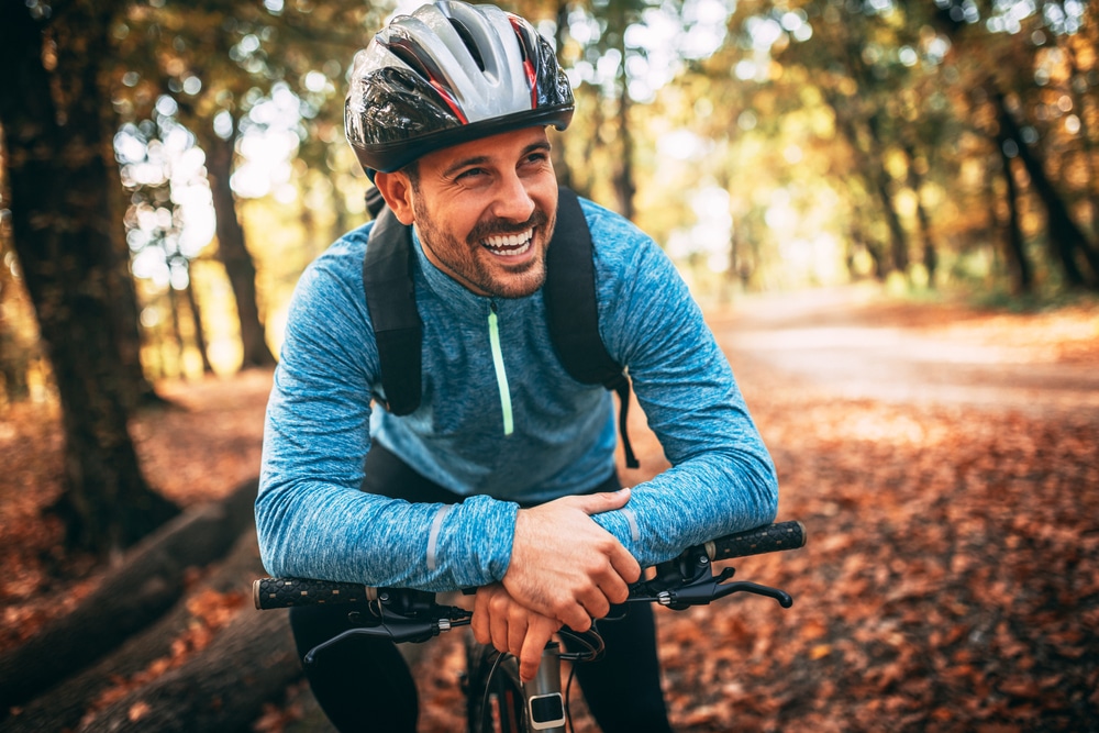 Man cycling through Maryland fall foliage near our Rock Hall Bed and Breakfast