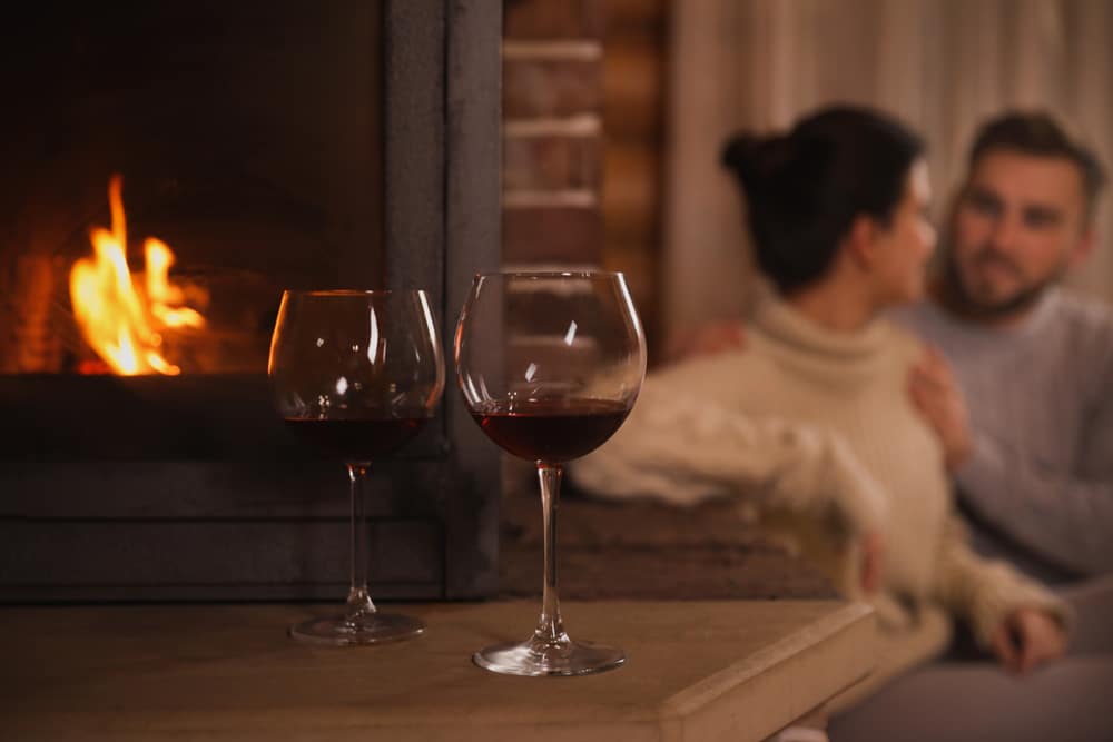 Couple having wine by the fire during their romantic Valentine's Day getaway near Washington DC