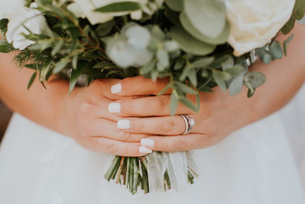 Expect a personalized, intimate experience when you book the best elopement packages in Maryland. This bride is holding her bouquet and showing off her new wedding ring.
