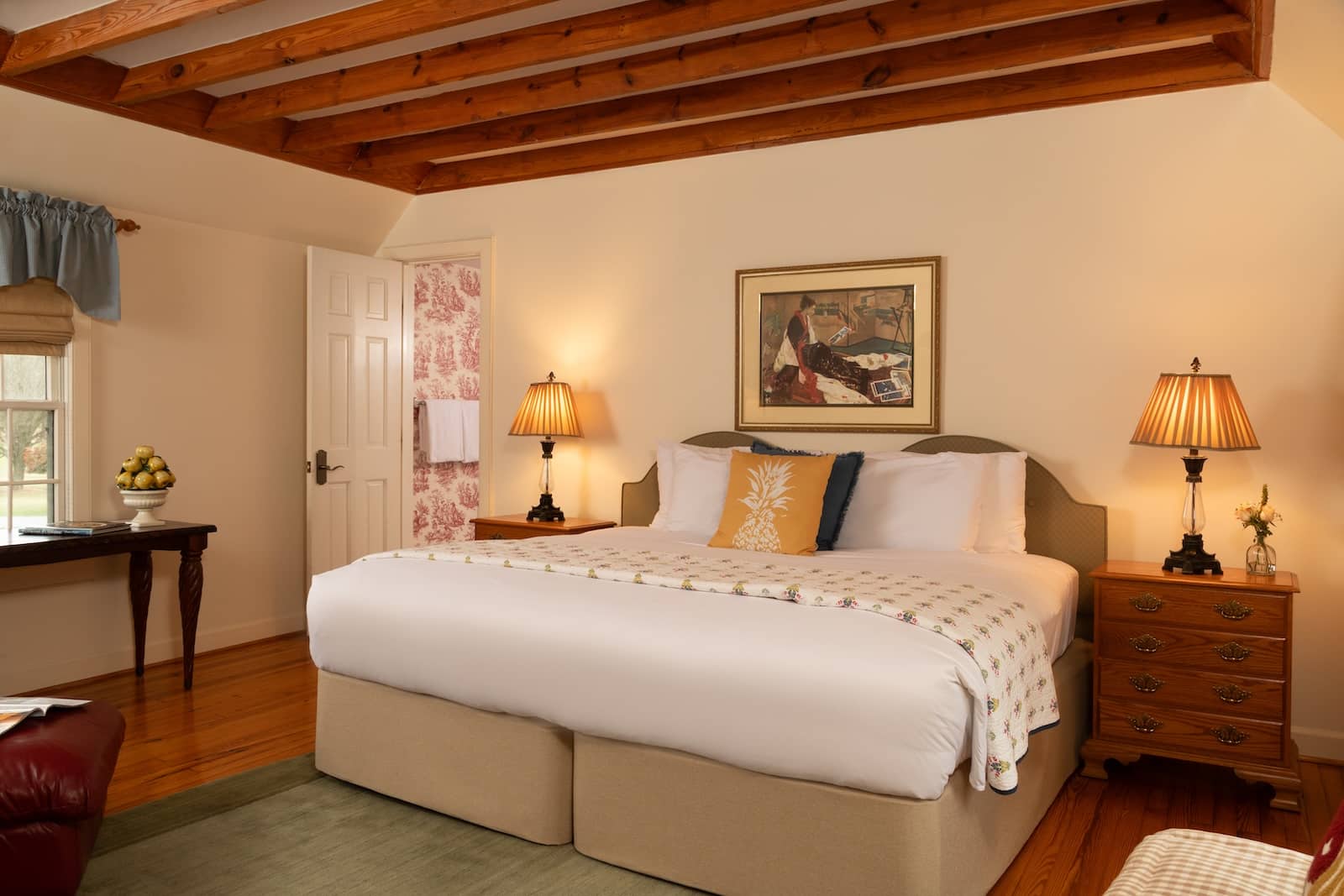 Discover the Best Things to Do in Chestertown, MD 2 A king size bed with artwork above and two nightstands with lamps beside it in a room at the best bed and breakfast in Maryland.