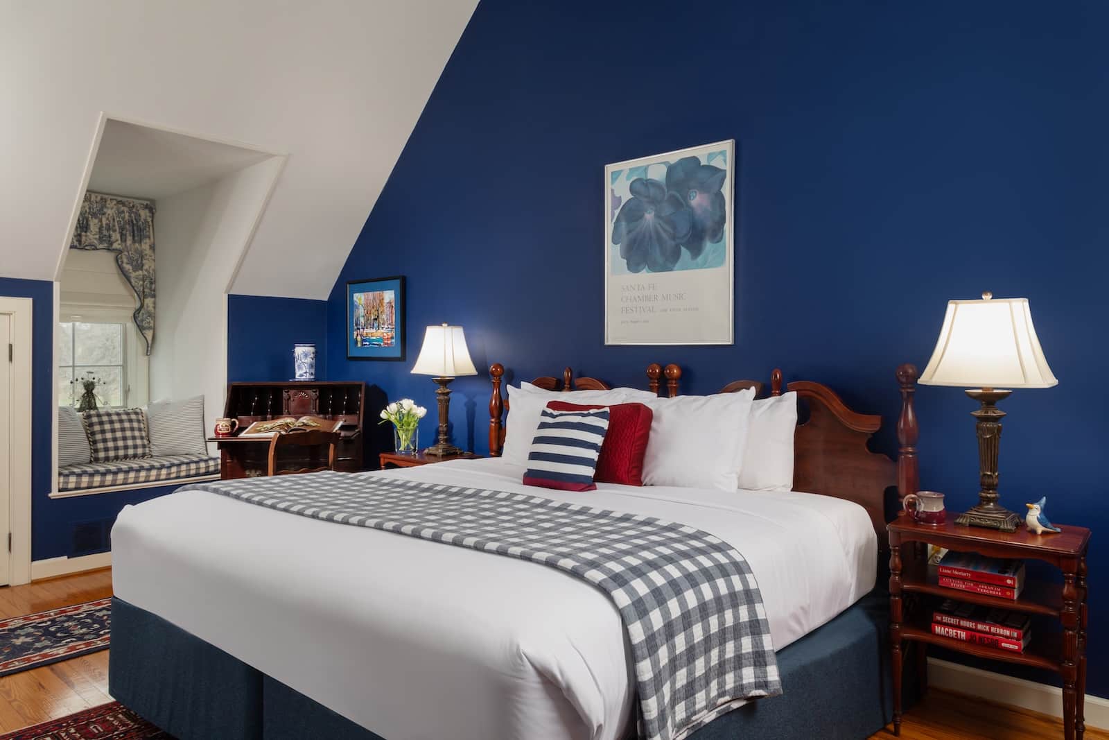 Best Waterfowl Hunting Guides & Outfitters Near Rock Hall, MD 2 A bed against a navy wall with art at a Bed and Breakfast in Maryland.